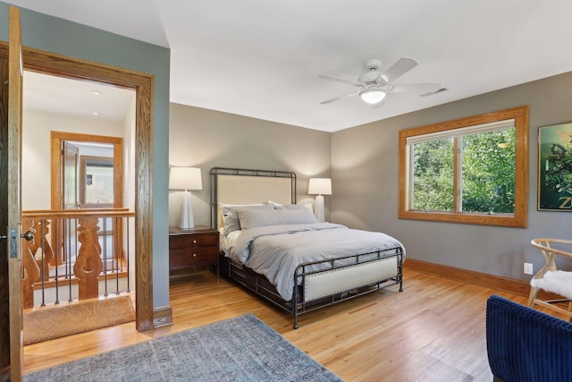 bedroom featuring baseboards, visible vents, ceiling fan, and wood finished floors