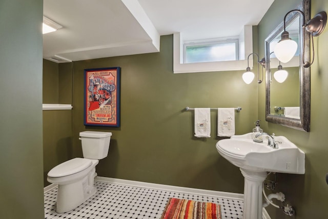 bathroom with toilet and baseboards