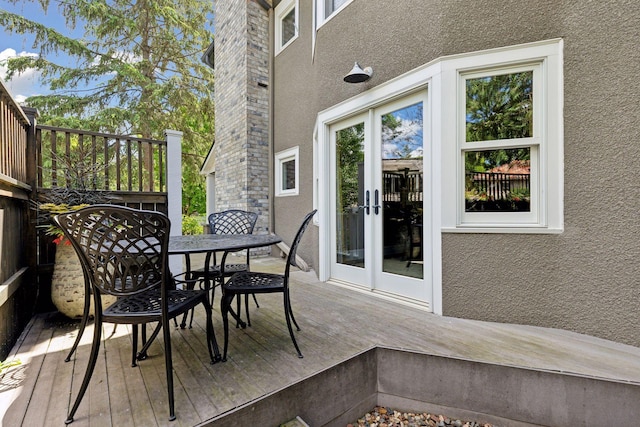 wooden deck featuring outdoor dining area and french doors