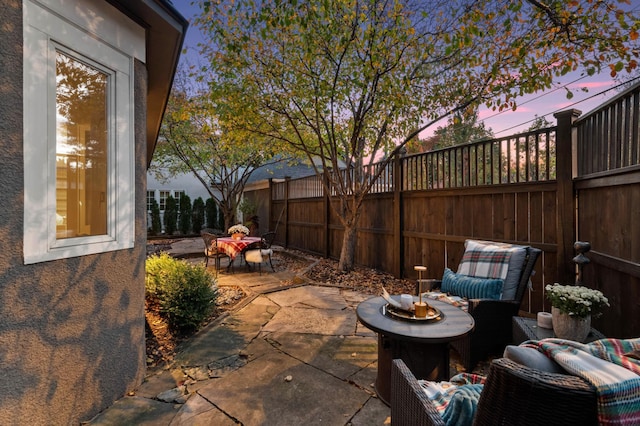 patio terrace at dusk with a fenced backyard