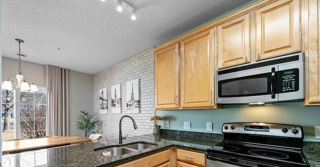 kitchen featuring a sink, a textured ceiling, appliances with stainless steel finishes, and light brown cabinets