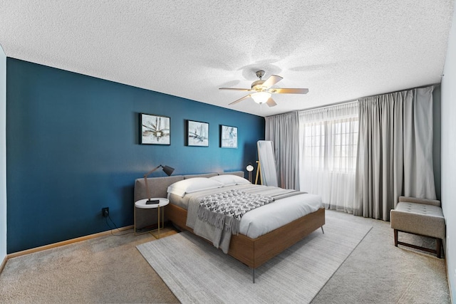 carpeted bedroom with baseboards, a textured ceiling, and ceiling fan