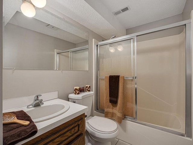 bathroom with shower / bath combination with glass door, visible vents, toilet, vanity, and a textured ceiling