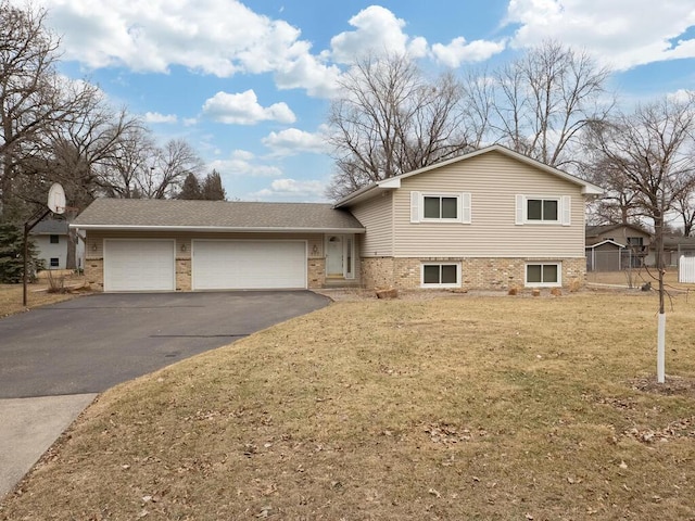 split level home with a garage, driveway, a front lawn, and brick siding