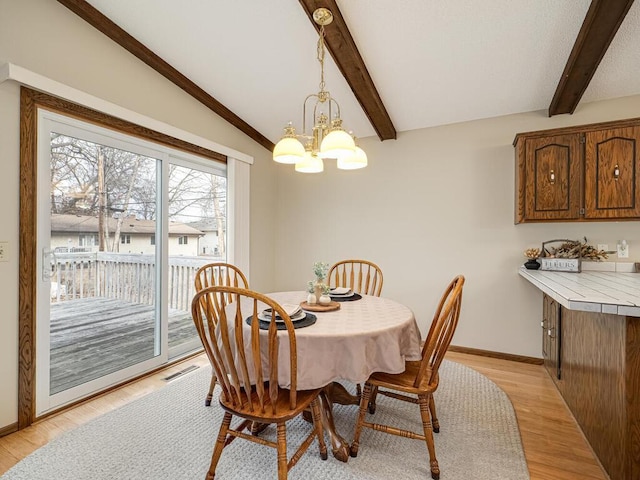 dining room with vaulted ceiling with beams, visible vents, light wood-style flooring, a chandelier, and baseboards