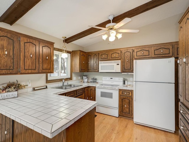 kitchen with white appliances, light wood finished floors, vaulted ceiling with beams, a peninsula, and a sink