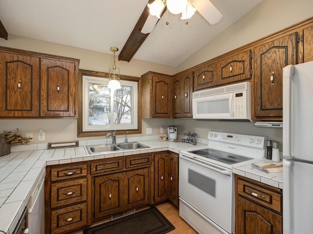 kitchen featuring tile countertops, white appliances, vaulted ceiling with beams, and a sink