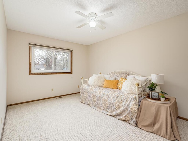 bedroom with visible vents, baseboards, a ceiling fan, carpet, and a textured ceiling