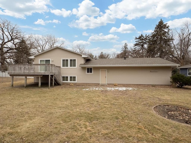 rear view of property with roof with shingles, a lawn, a wooden deck, and stairs