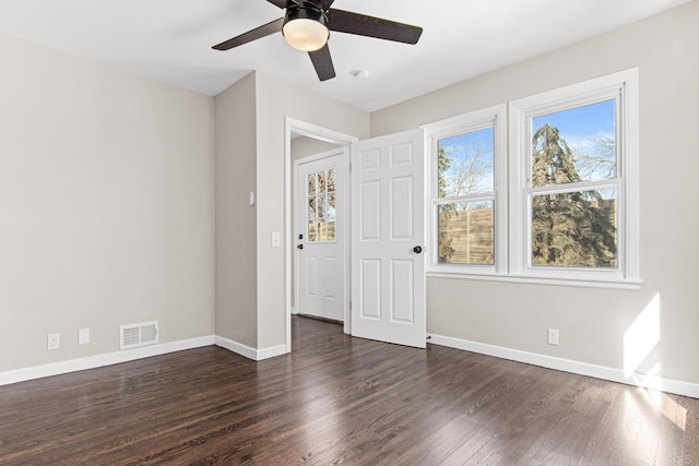 interior space featuring ceiling fan, visible vents, baseboards, and wood finished floors