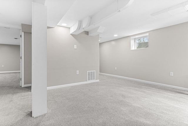 below grade area featuring recessed lighting, visible vents, baseboards, and carpet