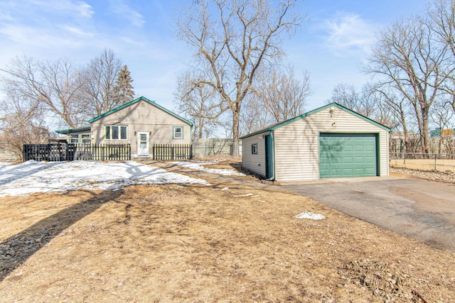 view of front of property with a garage, an outdoor structure, driveway, and fence