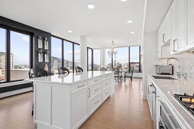 kitchen featuring light wood-style floors, plenty of natural light, backsplash, and a sink