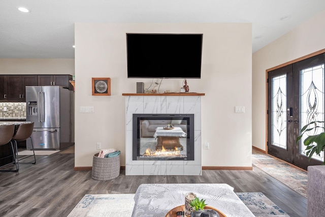 living room featuring wood finished floors, recessed lighting, french doors, baseboards, and a tile fireplace