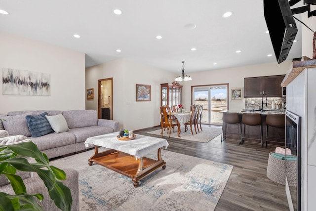 living room featuring a notable chandelier, recessed lighting, and wood finished floors