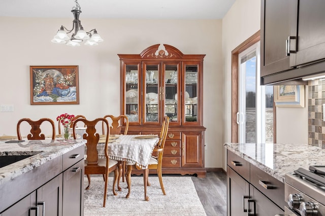 dining room with light wood-style flooring and an inviting chandelier