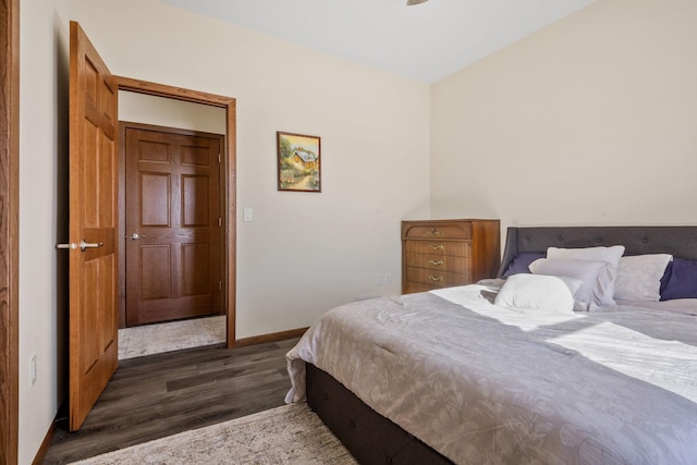 bedroom featuring baseboards and dark wood-style flooring