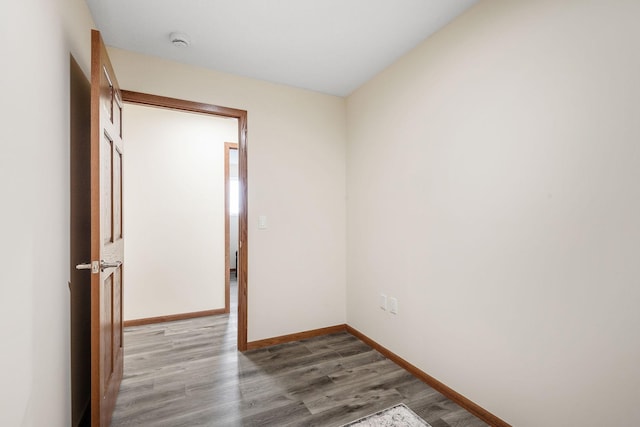 spare room featuring baseboards and wood finished floors