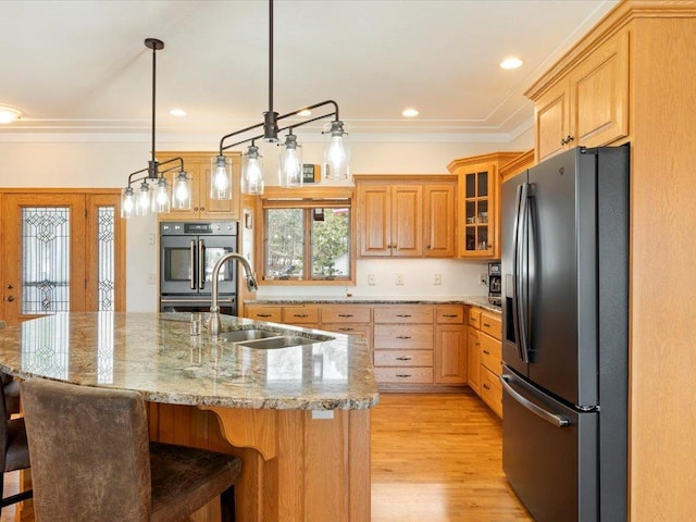 kitchen with double wall oven, a breakfast bar area, stainless steel fridge, and light wood finished floors