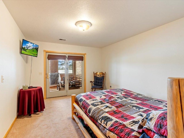 bedroom with visible vents, light carpet, a textured ceiling, and access to exterior