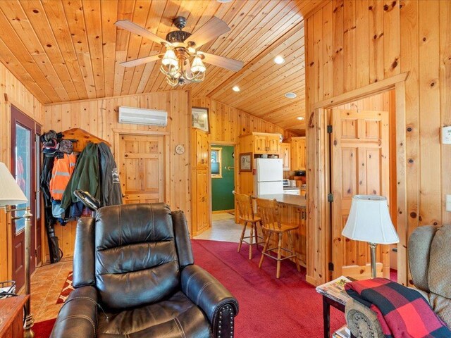 living area featuring wooden walls, a wall unit AC, vaulted ceiling, wooden ceiling, and a ceiling fan