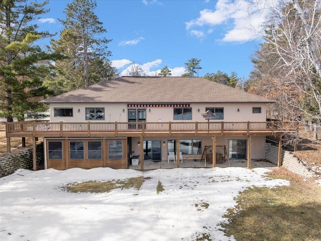 snow covered property with a deck