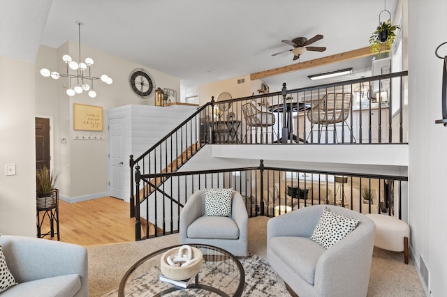 living area with visible vents, stairs, baseboards, and wood finished floors