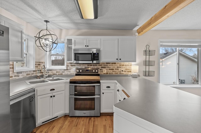 kitchen featuring white cabinetry, appliances with stainless steel finishes, and a sink