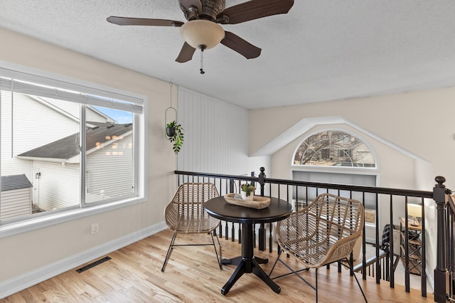 sitting room featuring a textured ceiling, wood finished floors, visible vents, and baseboards