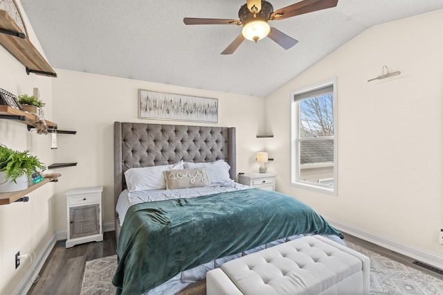 bedroom featuring a textured ceiling, wood finished floors, visible vents, baseboards, and vaulted ceiling