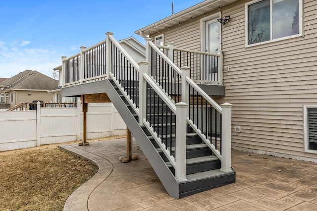 exterior space featuring a patio area, fence, and stairway