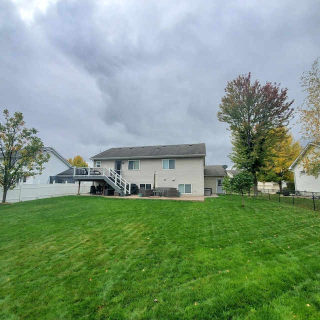 back of property featuring a patio area, a yard, stairway, and fence