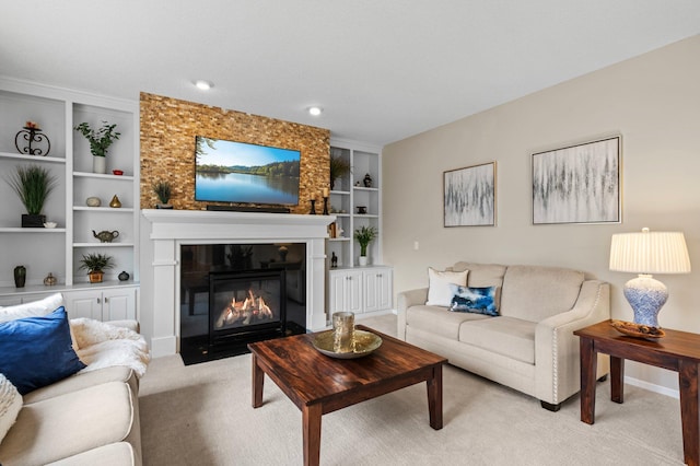 living room featuring a fireplace with flush hearth, built in features, baseboards, and light colored carpet