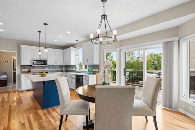 dining room featuring a notable chandelier, light wood finished floors, baseboards, and recessed lighting