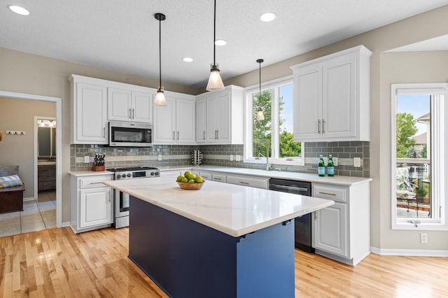 kitchen with stainless steel appliances, white cabinets, and decorative backsplash