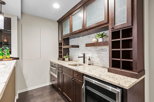 kitchen with dark brown cabinetry, beverage cooler, a sink, open shelves, and backsplash