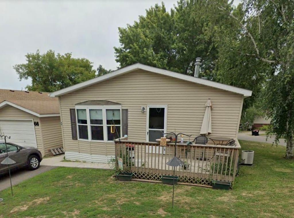 exterior space featuring a deck, central air condition unit, and a front lawn