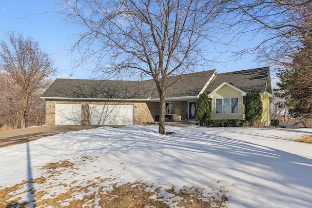 view of front of property with brick siding, driveway, and a garage