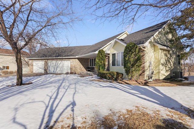 view of front facade with a garage, brick siding, roof with shingles, and driveway