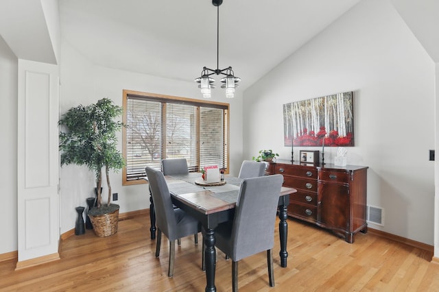 dining room featuring light wood-style flooring, baseboards, visible vents, and a chandelier