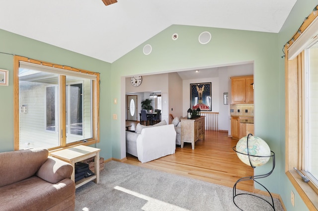 living area with vaulted ceiling and light wood-style floors