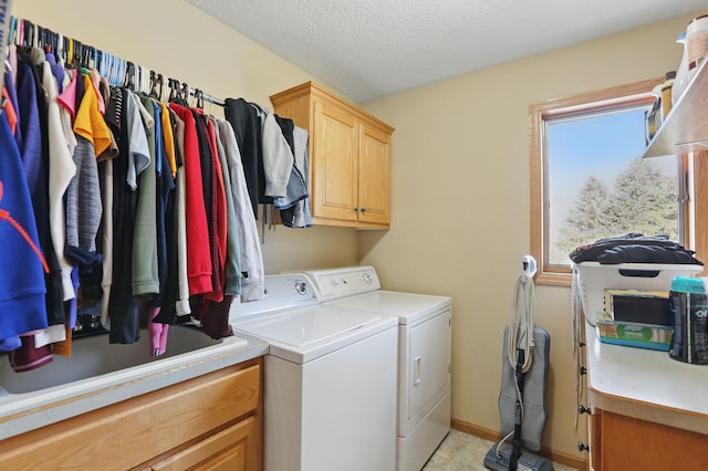 laundry area featuring baseboards, cabinet space, independent washer and dryer, and a textured ceiling