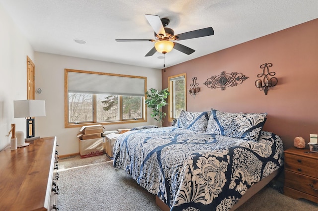 bedroom featuring baseboards, carpet, a ceiling fan, and a textured ceiling