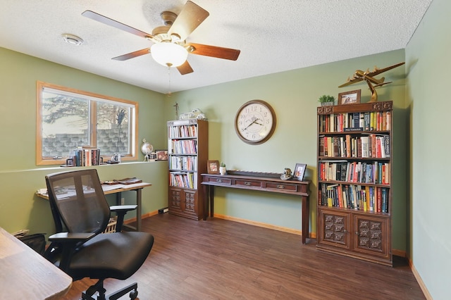 home office with baseboards, a textured ceiling, wood finished floors, and a ceiling fan