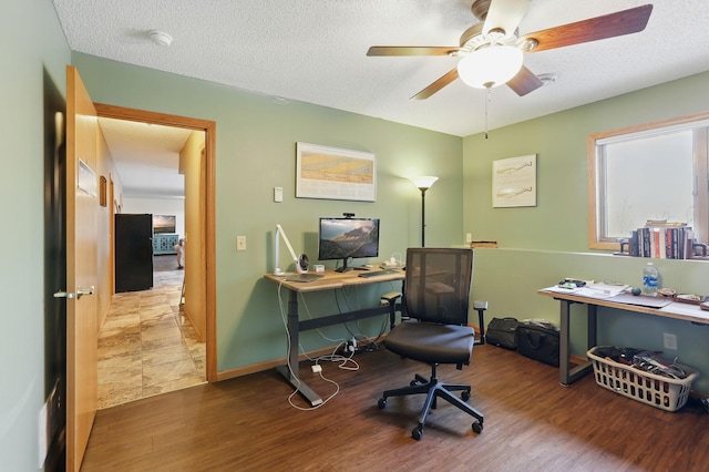 office area with ceiling fan, wood finished floors, baseboards, and a textured ceiling