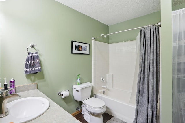 bathroom with wood finished floors, shower / bathtub combination with curtain, a sink, a textured ceiling, and toilet