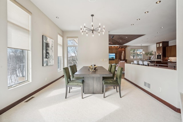 dining space featuring an inviting chandelier, visible vents, and light colored carpet