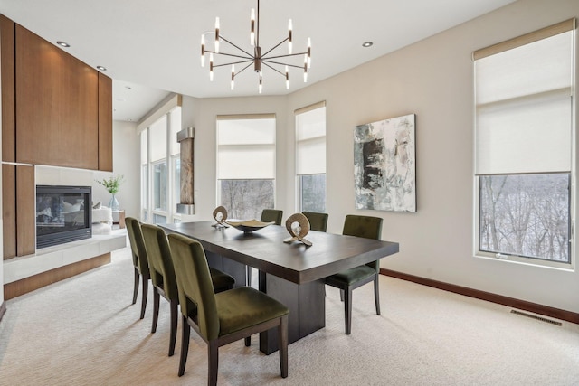 dining area featuring a wealth of natural light, visible vents, light carpet, and a tiled fireplace