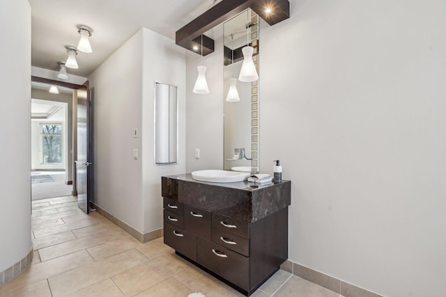 bathroom with vanity, baseboards, and tile patterned floors