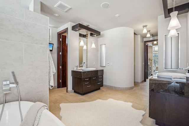 full bath featuring two vanities, a sink, visible vents, and tile patterned floors